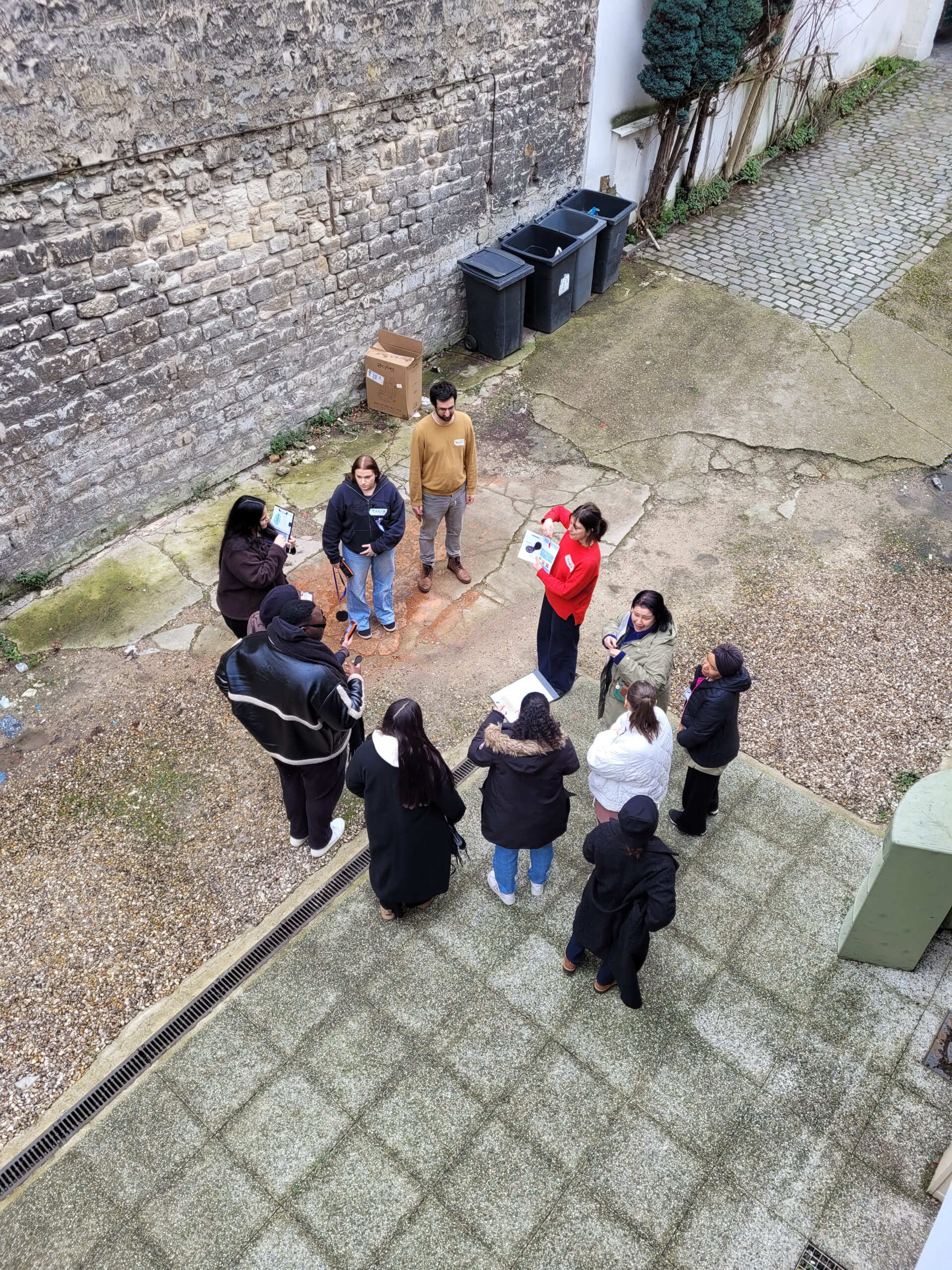 Un groupe participe à une mise en situation de formation dans une cour.