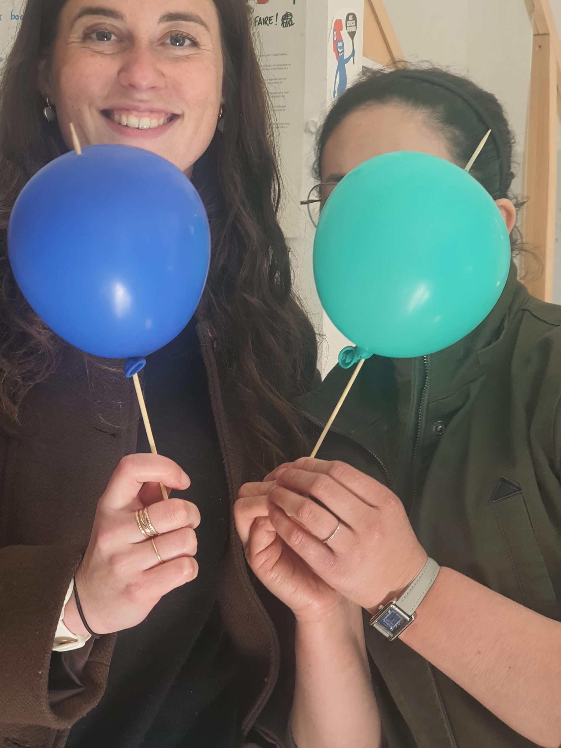 Deux participantes présentent une expérience avec des ballons pendant une FIA.